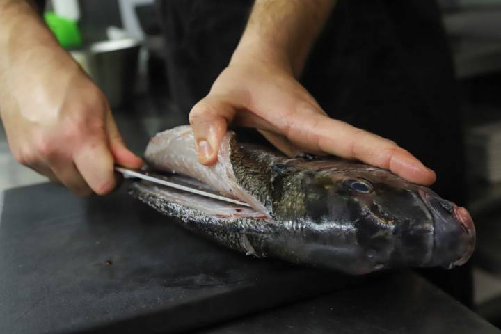 Uno de los cocineros, Álvaro Serrano, preparando la 'muxarra' (o pargo).