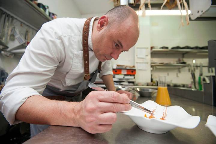 Nazario Cano en su cocina emplatando la sopa de galera y alcachofas.