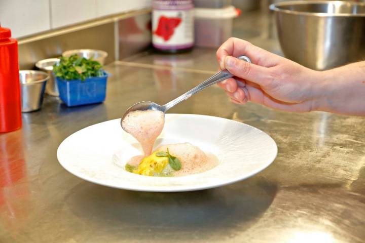 Bacalao con una salsa bearnesa de ají y sopa espumosa de salsa verde de curry verde.