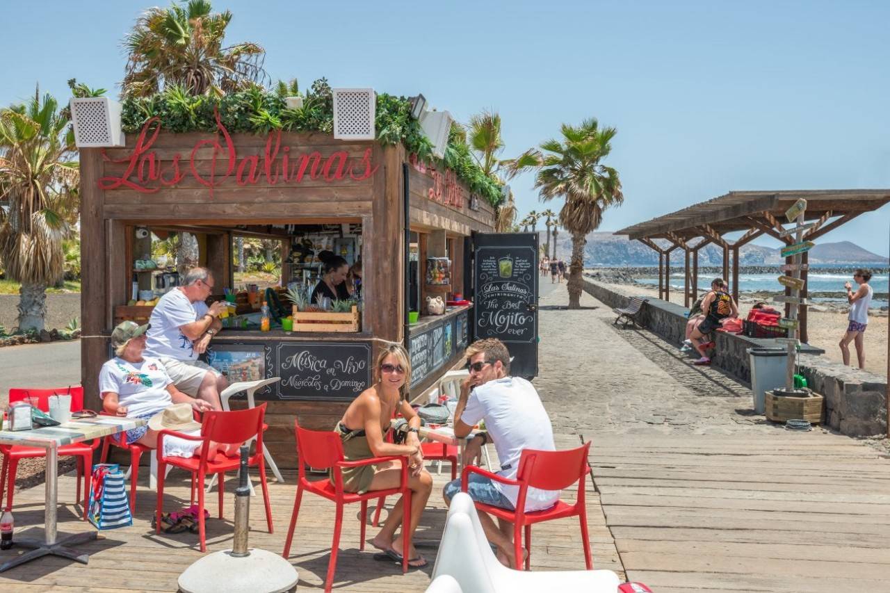 Papas y mojitos con los pies enterrados en la arena