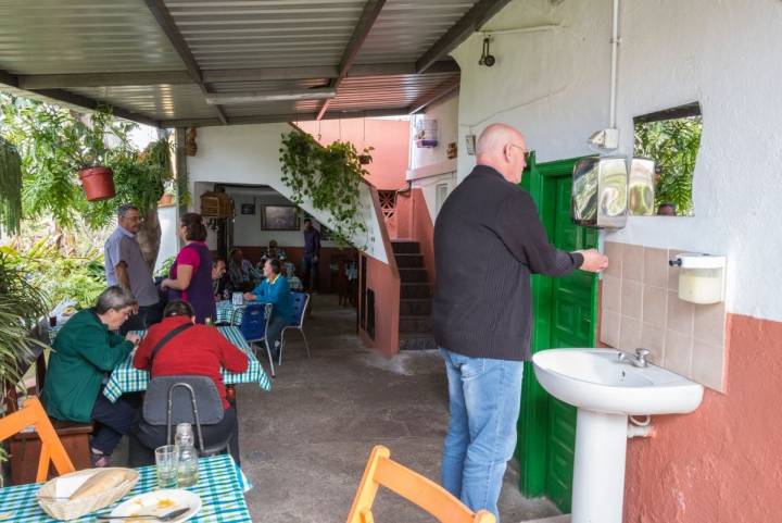 Las mesas en el patio del guachinche Las Galanas rodeados de macetas.