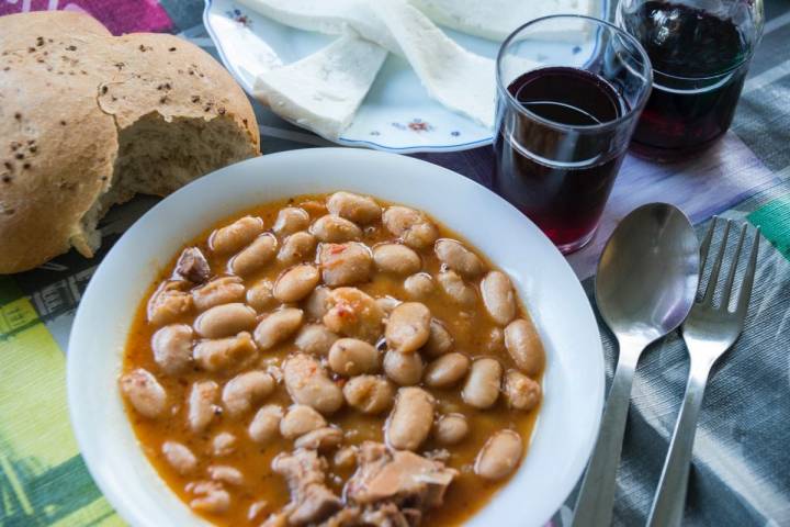 Plato de fabada del guachinche Zacatín, en Tenerife, junto al vino y el pan.