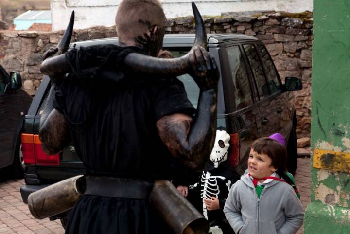 Unos niños miran asombrados a uno de los diablos. En pocos años, ellos también participarán en la tradición.