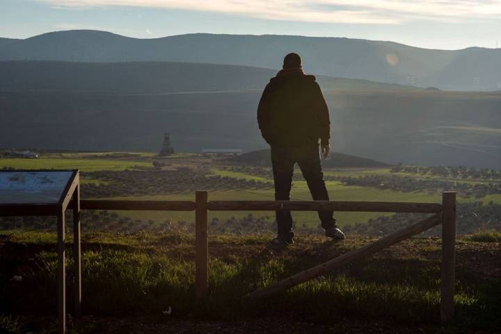 Un hombre frente a los prados del antiguo campo minero.